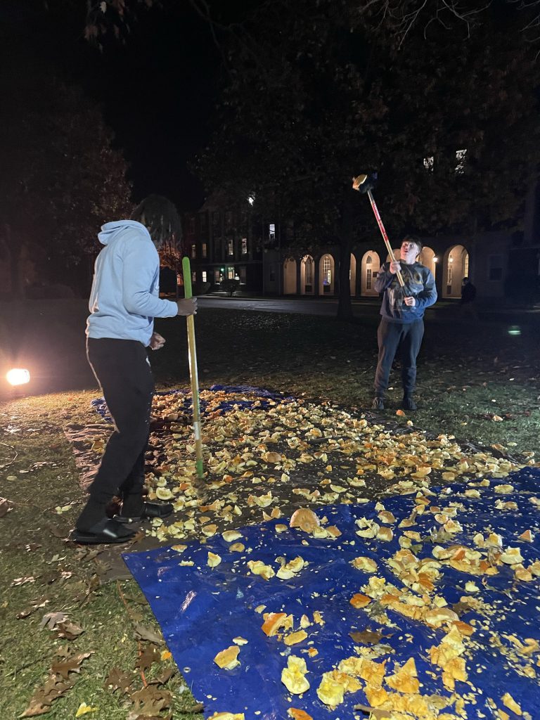 Two students chopping pumpkins in the Quad